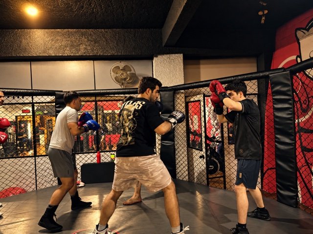 Alunos praticando boxe com luvas durante o treino