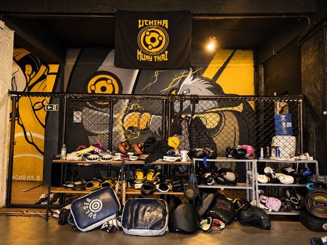 Luvas e equipamentos de treino organizados no CT Uchiha